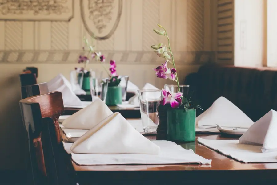 Restaurant tables laid with napkins and flowers
